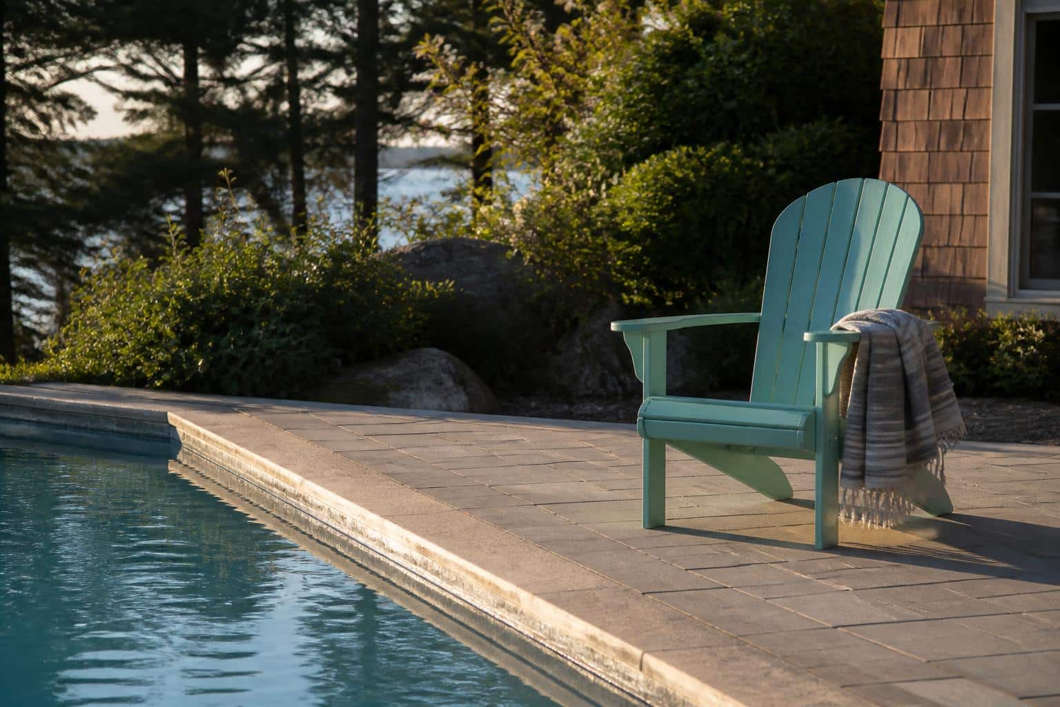 Seafoam adirondack chair with towel draped over arm by a pool