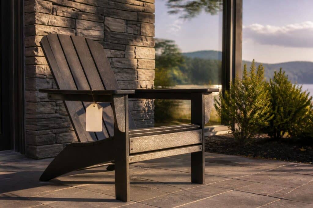 Adirondack chair on a patio with a small blank price tag hanging from the arm