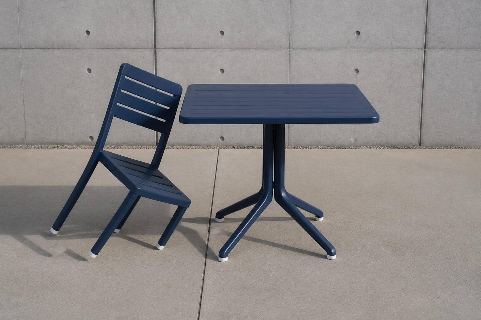 Cafe chairs on a swept concrete patio