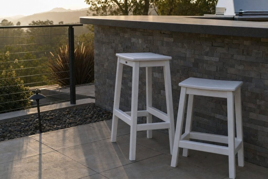 Two white polymer outdoor stools of different heights beside a kitchen counter