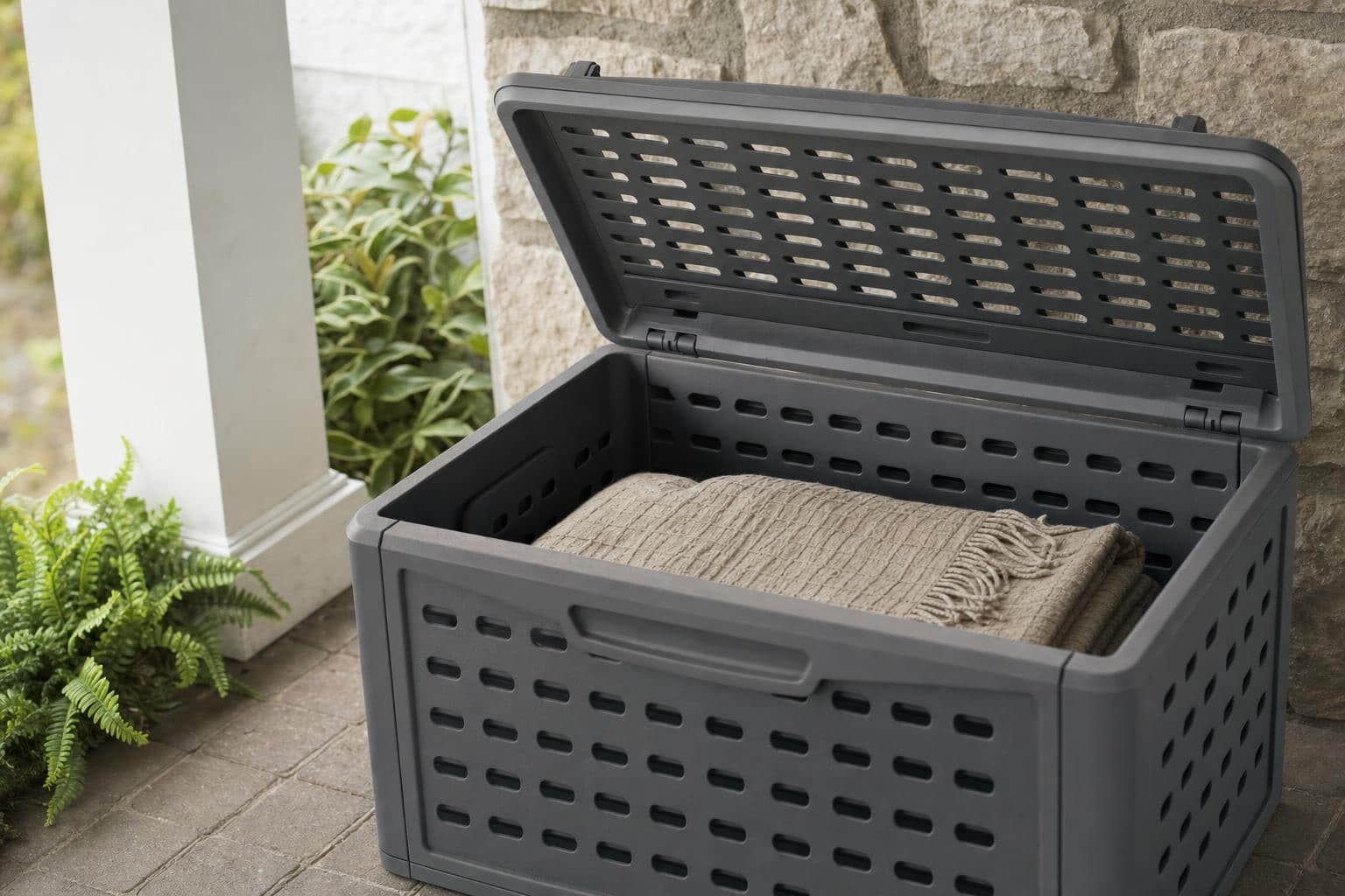 Folded outdoor throw stored in a ventilated patio bin