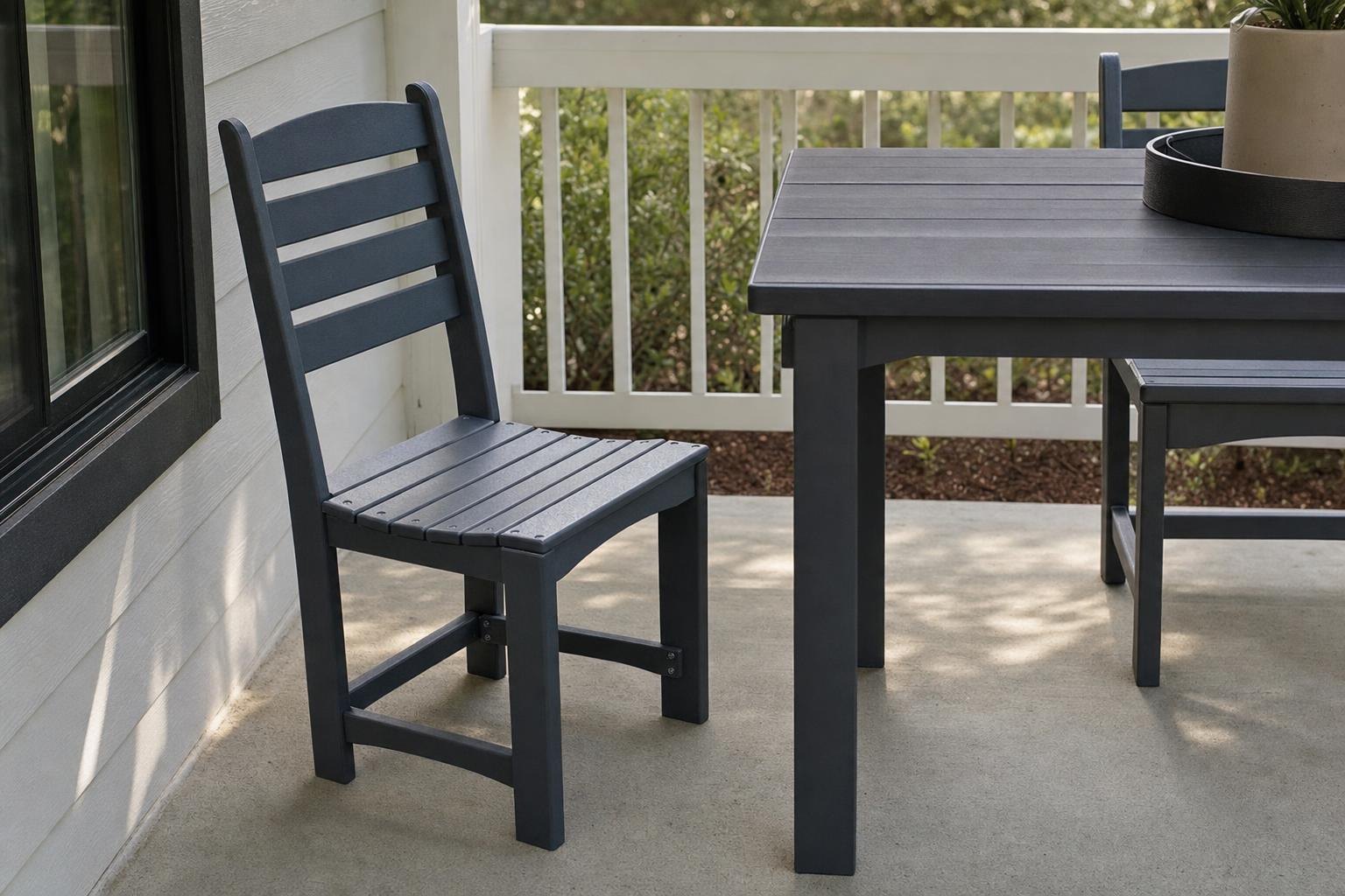 A dark armless cafe chair at a dining-height outdoor table on a porch