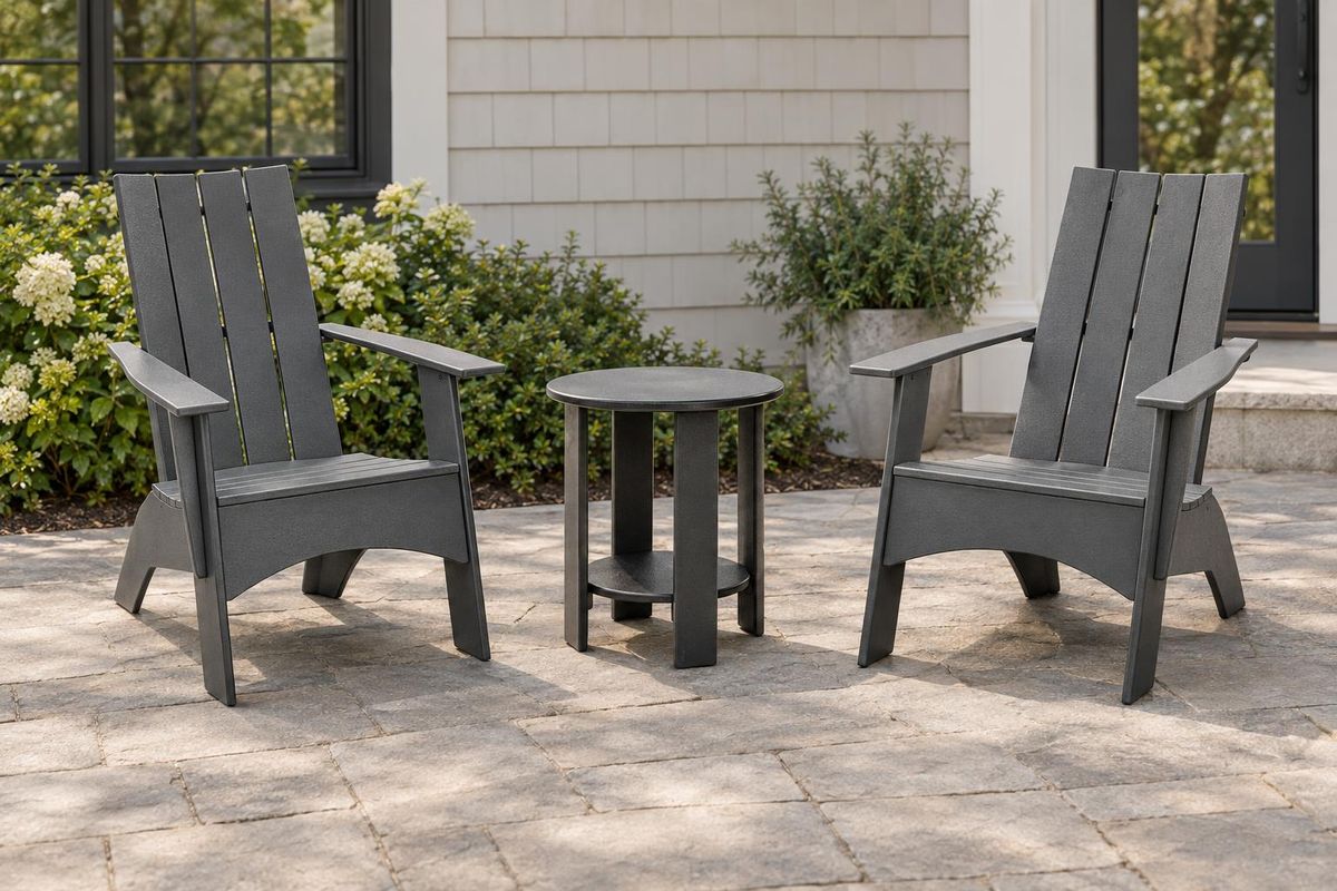 Two charcoal Adirondack chairs facing each other across a round end table with a clear gap on each side